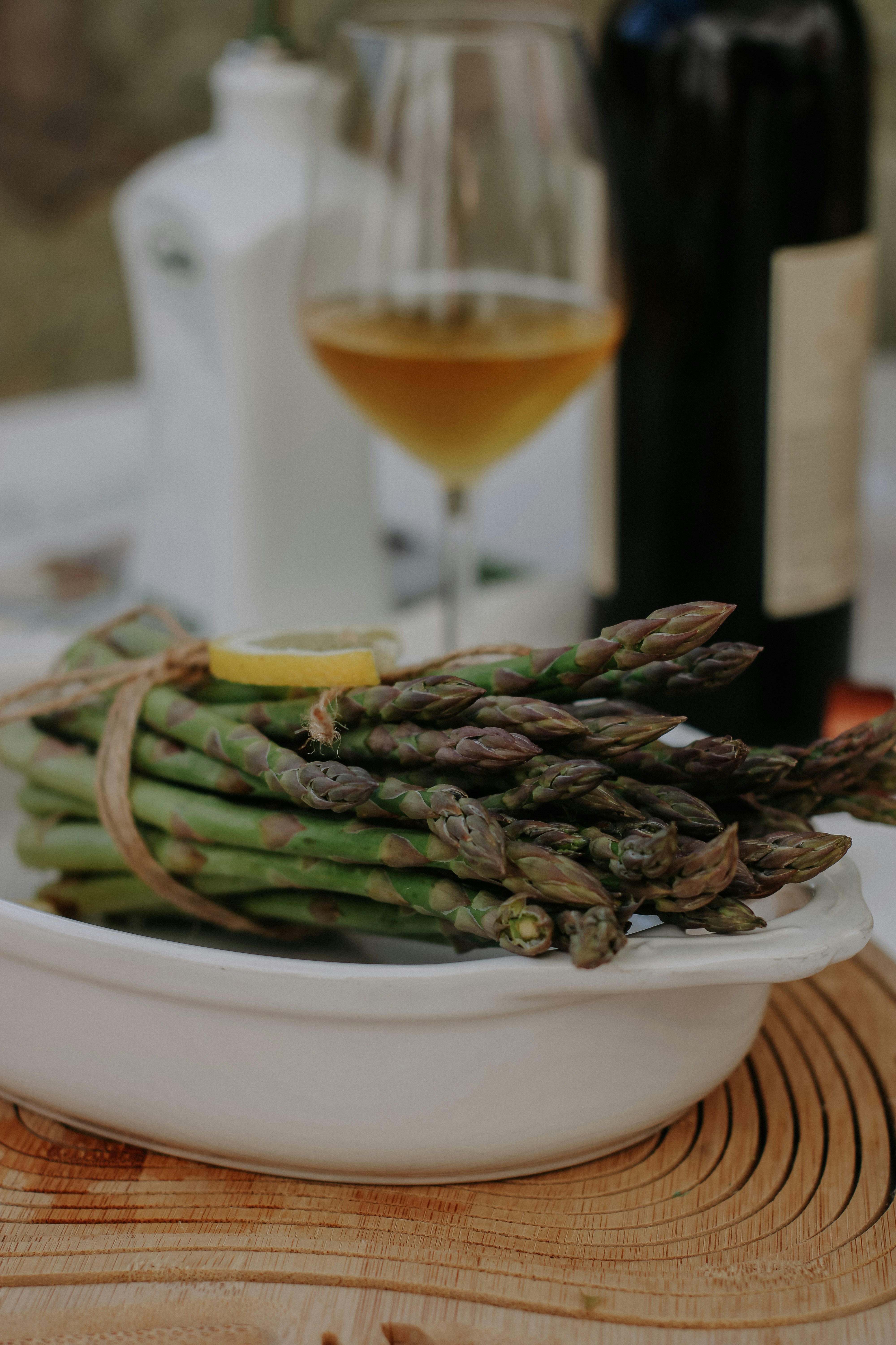 Espárragos verdes grillados con marcas de parrilla, servidos con huevo poché y manteca de limón.
